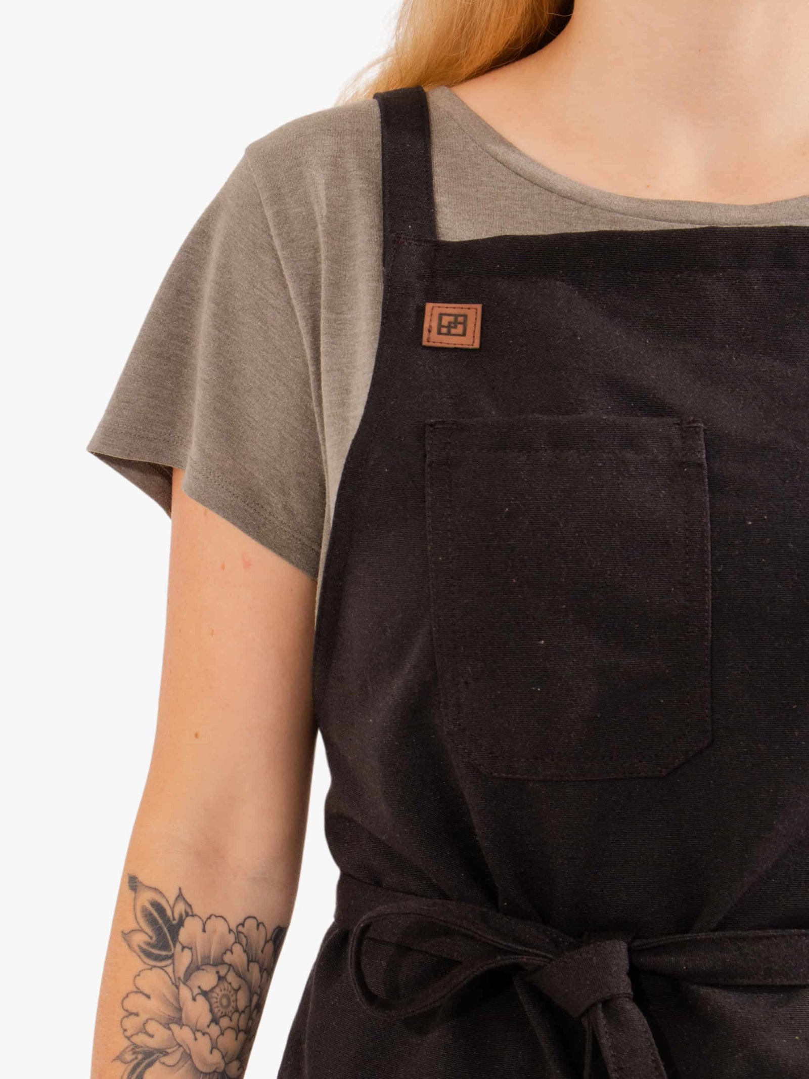 Close-up of the Blackcurrant Black apron chest pocket and logo