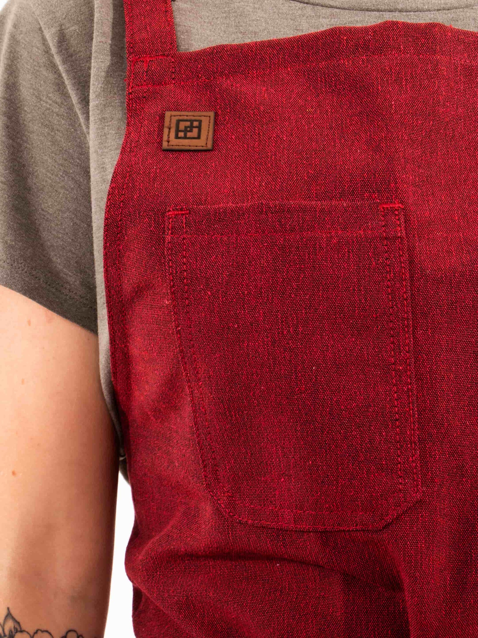 Close-up of the Cherry Red apron chest pocket and logo